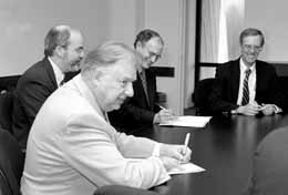 NIU President Peters (foreground) and Fermilab Director Michael Witherell sign the Memo of Understanding