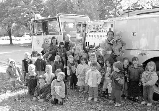 Russ Wood (left) and Alex Silva gather with kids from the Fermilab day-care center for Fire Prevention week