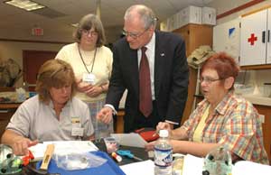 Marburger and Marge Bardeen (standing, left), head of Fermilabs Education Office, confer with local teachers undergoing training at the Leon Lederman Science Education Center.