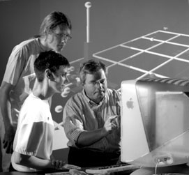 John Womersley (right) makes a point while examining a data display with Amber Boehnlein and Gustaaf Brooijmans.